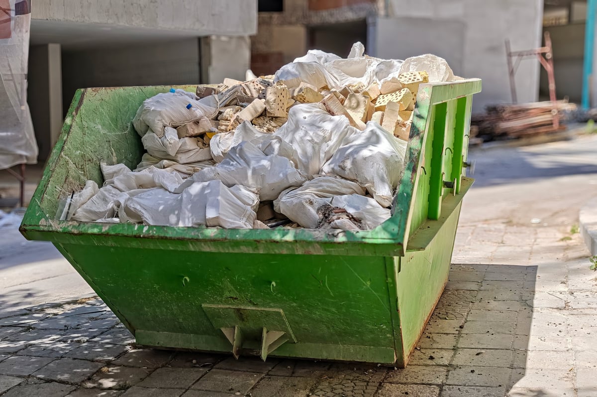 Dumpster full of construction debris on an urban street